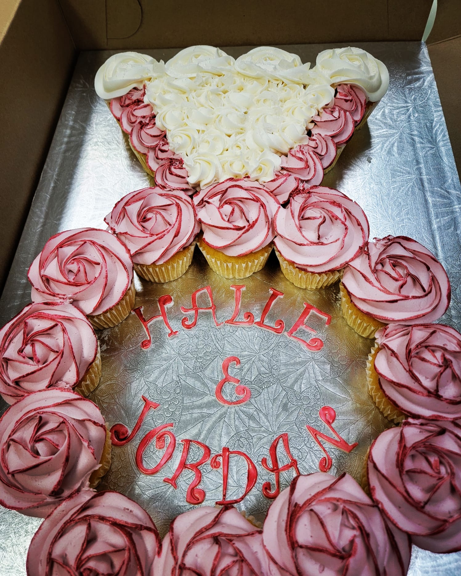 Cupcakes assemblés en bague de fiançailles, roses de glaçage rose et blanc, noms Halle & Jordan en rouge.
